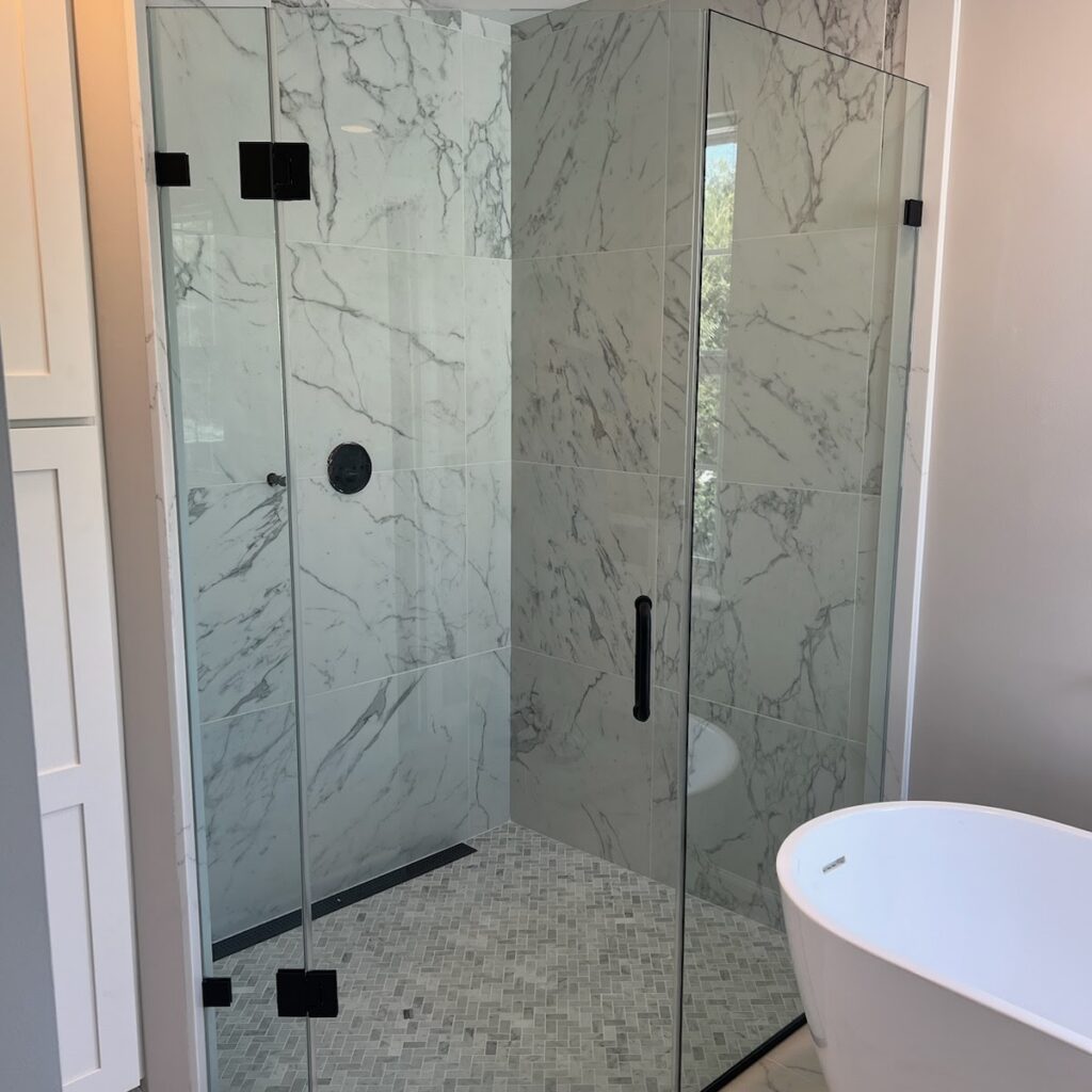 Luxury walk-in shower installation with tile walls and frameless glass by Sparkk Construction bathroom contractors