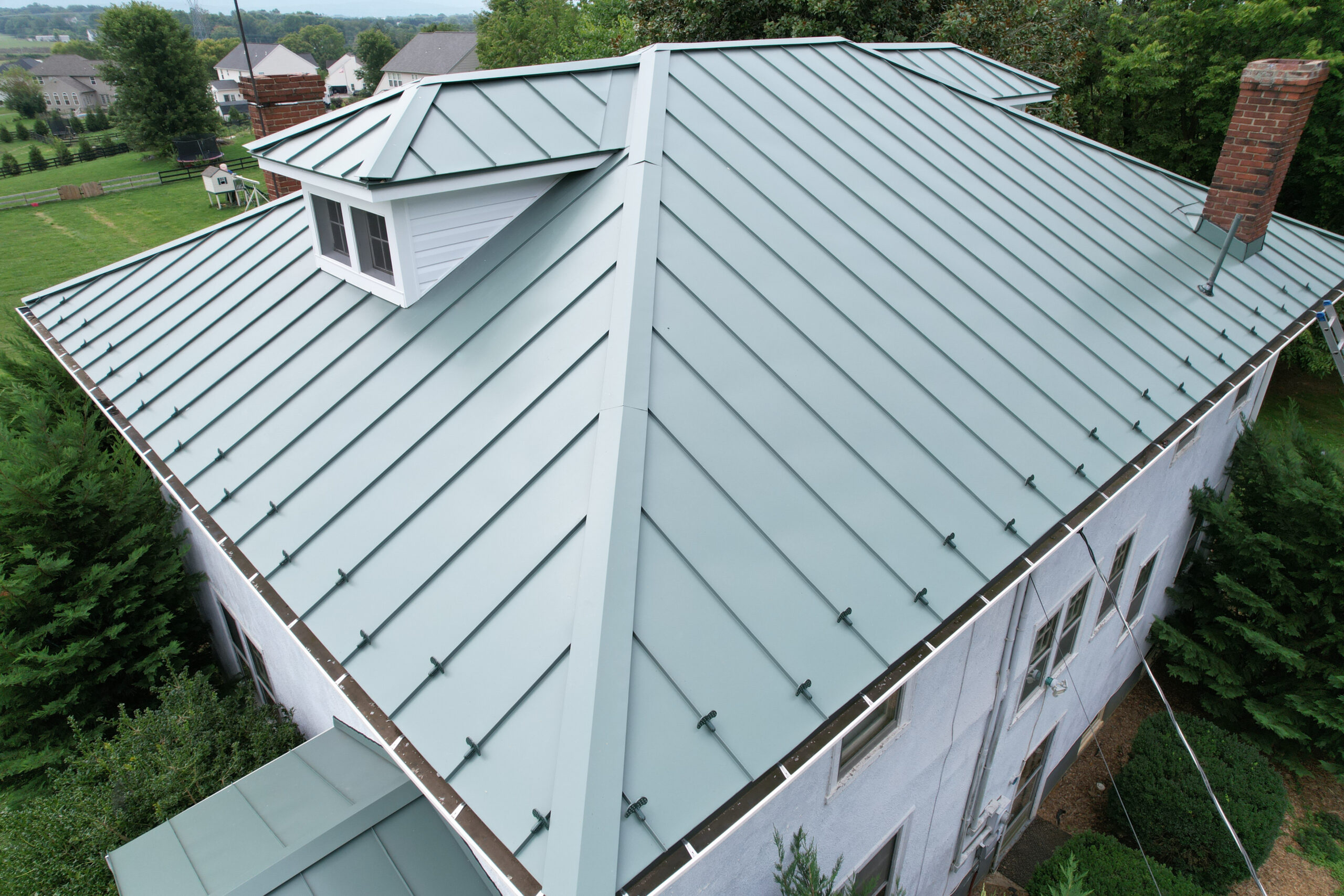 Standing seam metal roof installed by local roofing contractor in Fredericksburg VA featuring concealed fastener system
