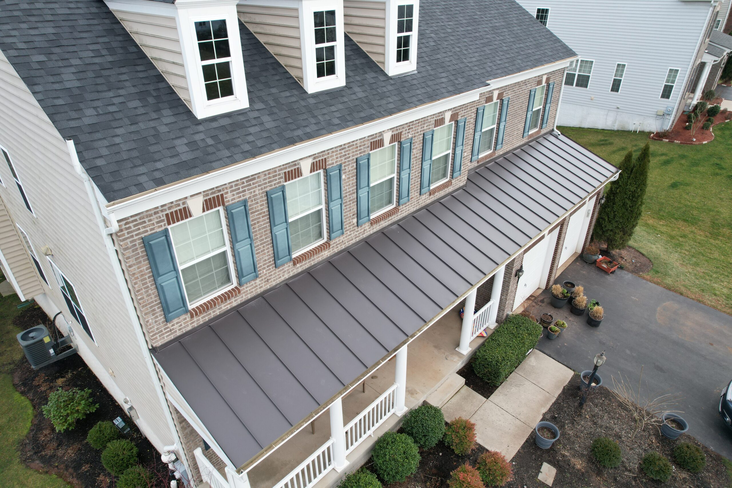 Roofing crew installing standing seam metal panels fabricated on site for precision fit and durability